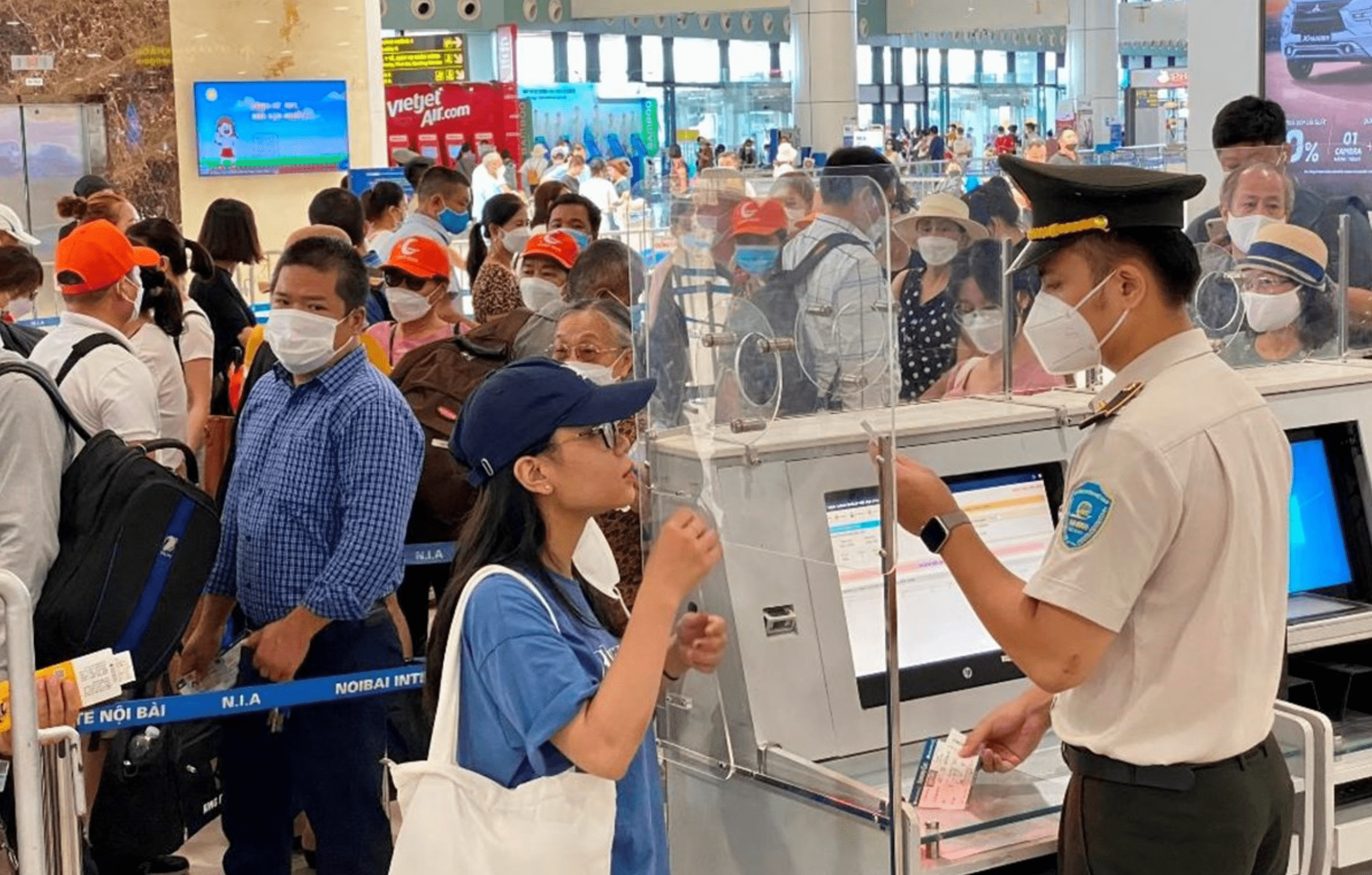 Hành khách làm thủ tục kiểm tra giấy tờ trước khi vào soi chiếu để đi máy bay. (Ảnh: PV/Vietnam+)